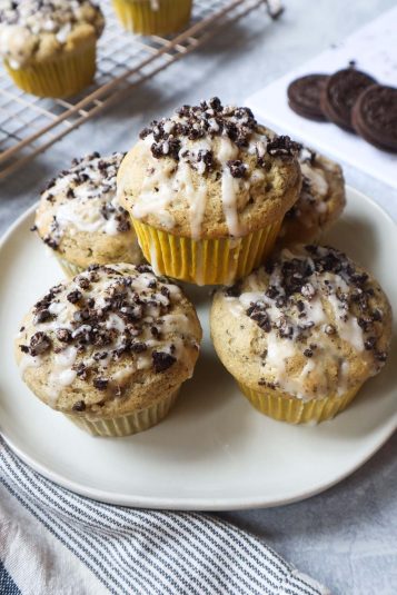 Plate with oreo muffins stacked with oreo crumbs and glaze.