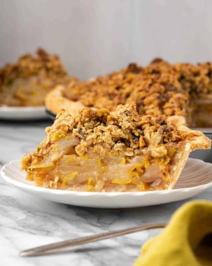 A slice of pear crumble pie served on a small dessert plate.