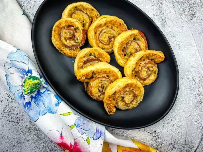 A plate of Prosciutto & Parmesan Puff Pastry pinwheels.