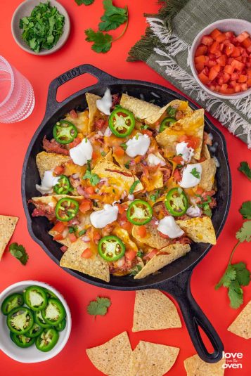 A cast iron skillet with pulled pork nachos in it.