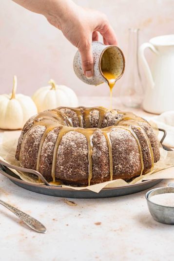 Pouring maple glaze on pumpkin cake.