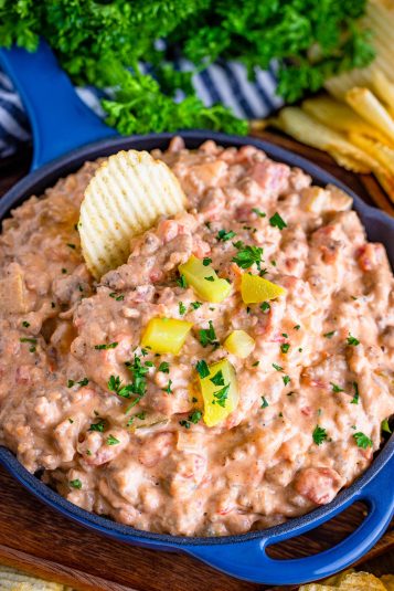 Blue bowl filled with creamy bacon and cheese dip, great for game day snacking.
