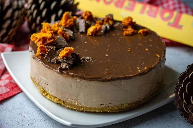 Toblerone chocolate on a wooden board with its vardboard package behind it.