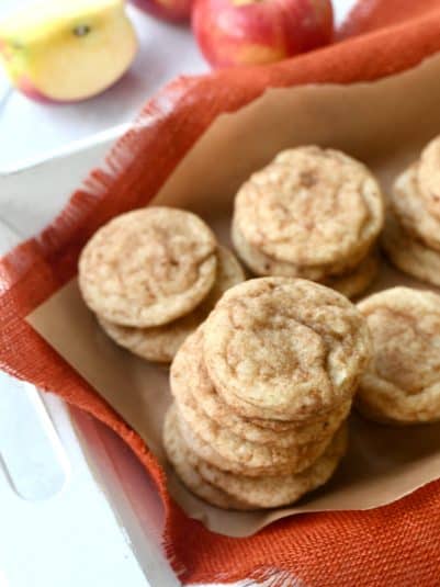 Stack of apple cider cinnamon cookies in brown parchment.