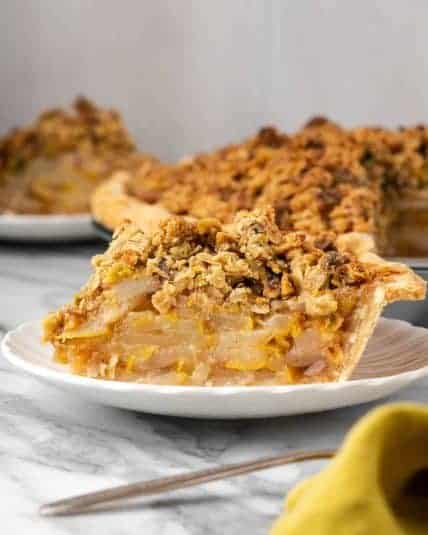 A slice of pear crumble pie served on a small dessert plate.