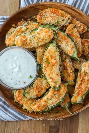 Buffalo wings and ranch dip next to jalapeno poppers filled with creamy cheese and topped with crispy Panko.