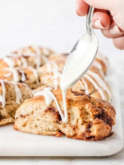 Drizzling glaze on cinnamon scone.