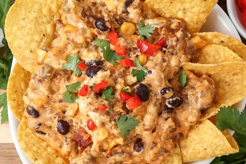 A layered taco dip with ground beef and cheese.