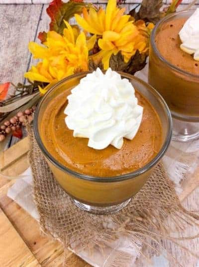 pumpkin mousse in mini trifle dishes topped with homemade whipped cream.