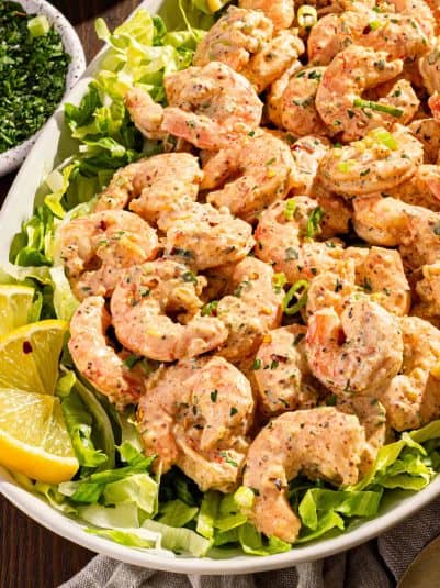 A platter of shrimp remoulade with lemon.