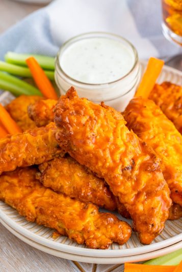 Buffalo Chicken Tenders on plate with ranch and vegetables.
