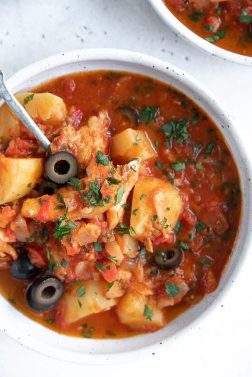 Overhead image of two white shallow bowls filled with Salt Cod Stew.