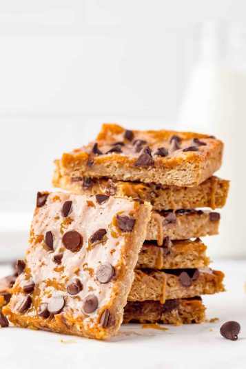 Ooey gooey Caramel Oatmeal Bars stacked with one bite.