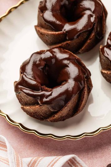 Flat lay image of chocolate mini Bundt cake with chococlate chips, milk in the sides.
