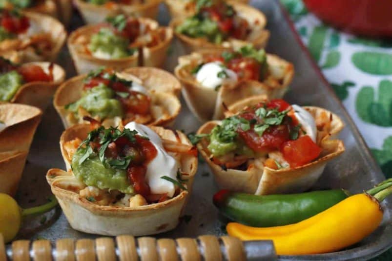 Mini Swiss cheese quiches on a white platter.