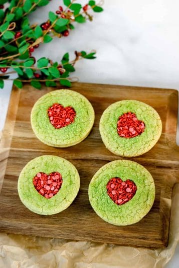 Sugar cookie with heart cut in the center filled with sprinkles.