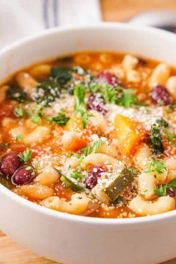 Close up of white bowl with minestrone soup.