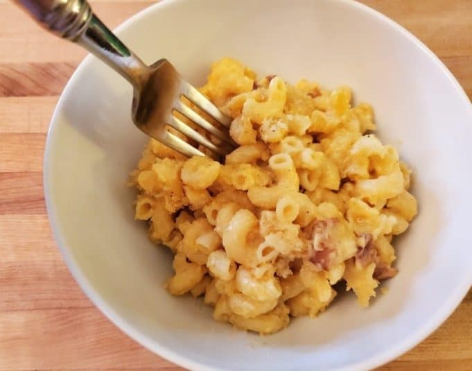Cheesy scalloped potatoes in a casserole dish on a blue wooden table.