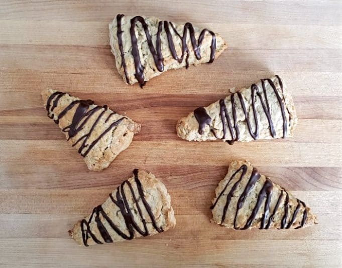 Image shows Chocolate drizzled mocha scones on a cutting board.