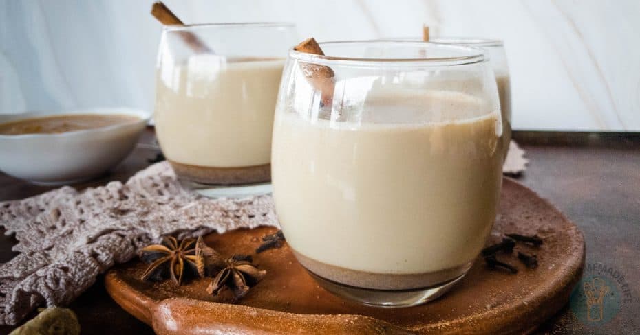 A glass of coffee jelly with heavy cream on a fabric background.