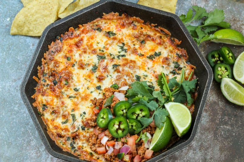 Close up image of the garnished chorizo and cheese dip still in the cast iron skillet.