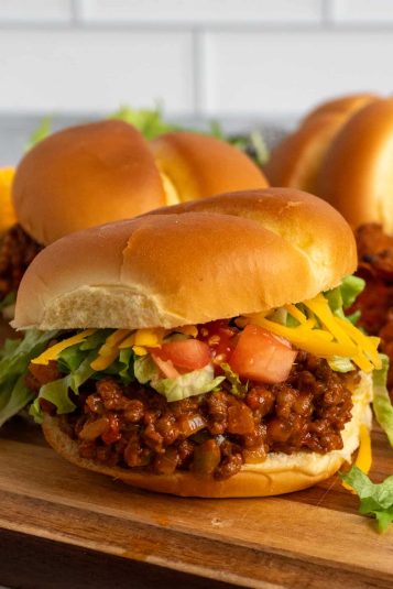 Close up of a taco Joes sandwich on a wood cutting board.