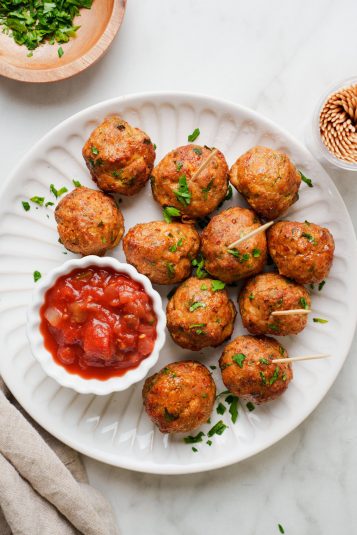 Air fryer turkey meatballs with salsa on a white background.