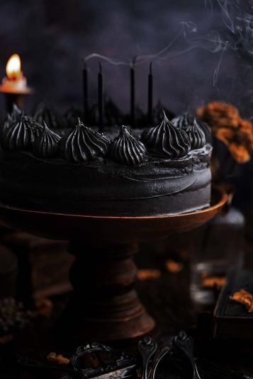 Black velvet layer cake with candles and smoke.