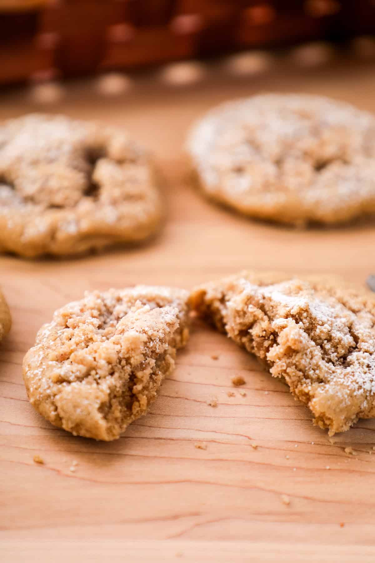 a coffee cake cookie topped with streusel and powdered sugar cut in half.