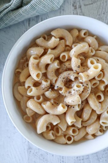 Cottage cheese mac and cheese with fresh ground pepper in a white bowl.