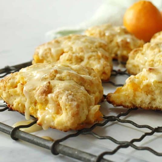 Muffins in a pan with icing and walnuts.