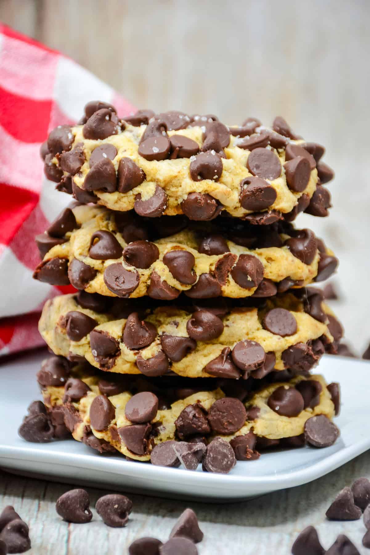 a stack of 4 chocolate chip cookies coated in chocolate chip and sea salt.