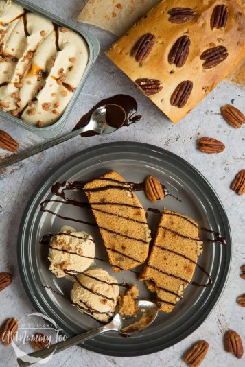Butterscotch pecan ice cream loaf, pictured sliced and surrounded by ice cream and toppings.