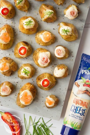 Stuffed mini baked potatoes topped with Primula cheese, peppers, chives, ham and salmon - a delicious festive starter or snack.