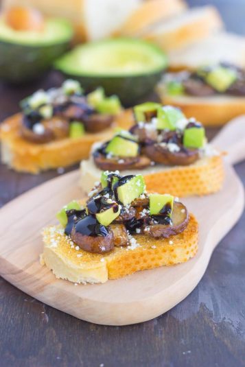 Mushroom, Avocado and Feta Toast on a wooden board.