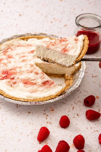 The pie slice is being held over the top of the pie.