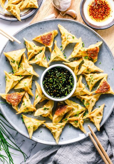 Overhead image pork and chive dumplings on a grey plate.