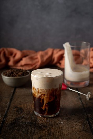 A glass of cold brew with pumpkin cream cold foam on top.