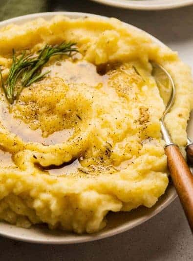 Potatoes topped with browned butter and a sprig of rosemary.
