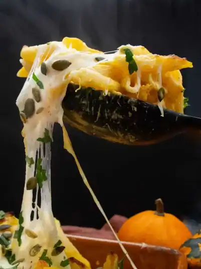 Spider Spooky Pasta on a plate with olive spiders on a web in the orange sauce.