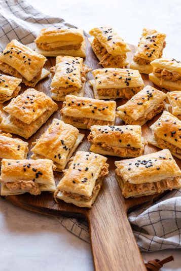 Sun-dried tomato chicken puffs arranged on a wooden board, ready to serve.
