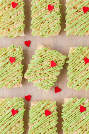 A row of Grinch Rice Krispies treats with the center one tilted.