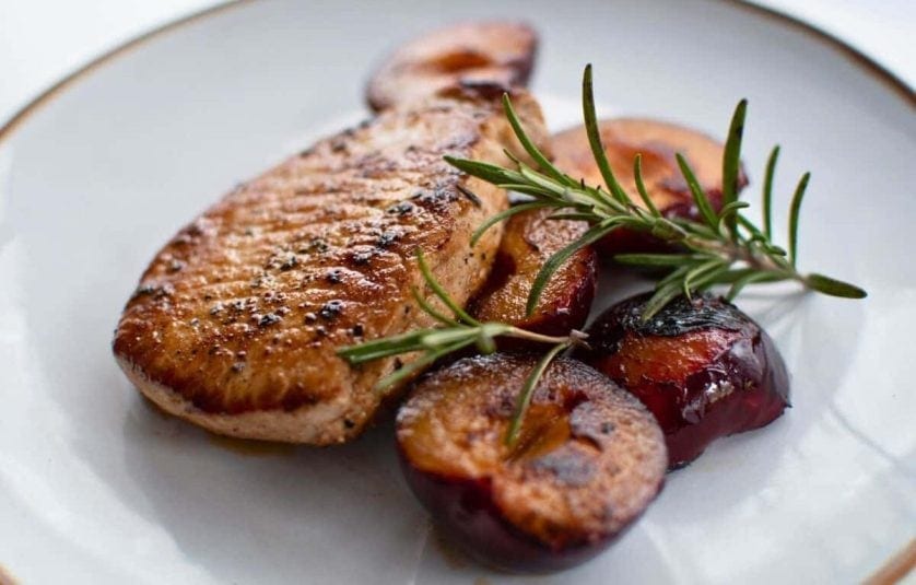 A display of Pan-Fried Pork Chops with Plums & Rosemary.