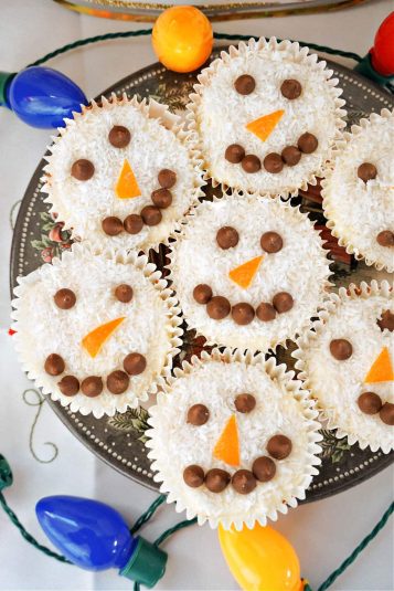 A plate with 7 snowman cupcakes.