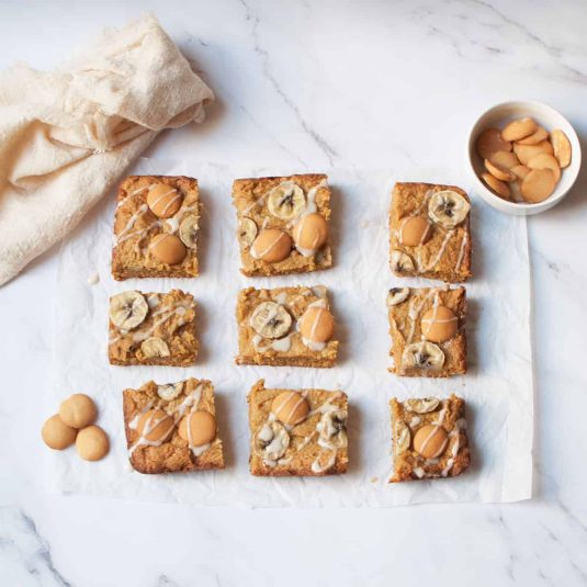 Banana pudding brownies with vanilla wafers beside them.