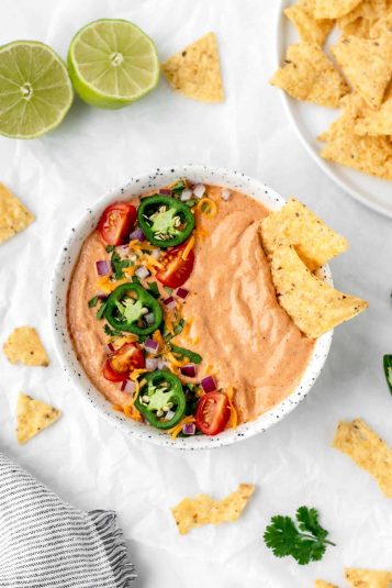 A birds-eye view of a bowl of cottage cheese queso on a table.