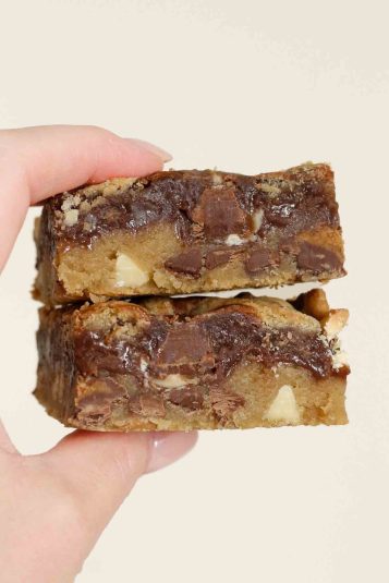 hand holding up 2 moose tracks cookie bars.