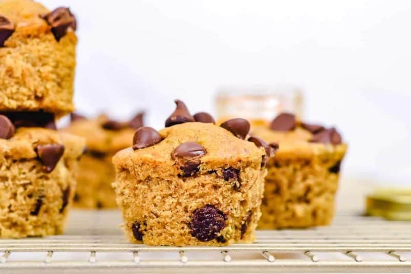 A bowl of chicken and dumplings with a spoon and parsley.
