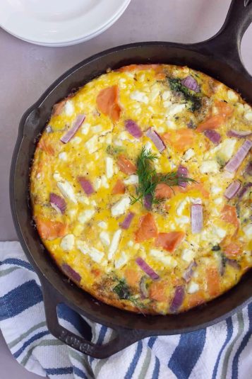 Salmon frittata in a black skillet.