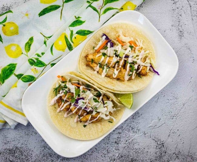 Baja fish tacos on a white plate.